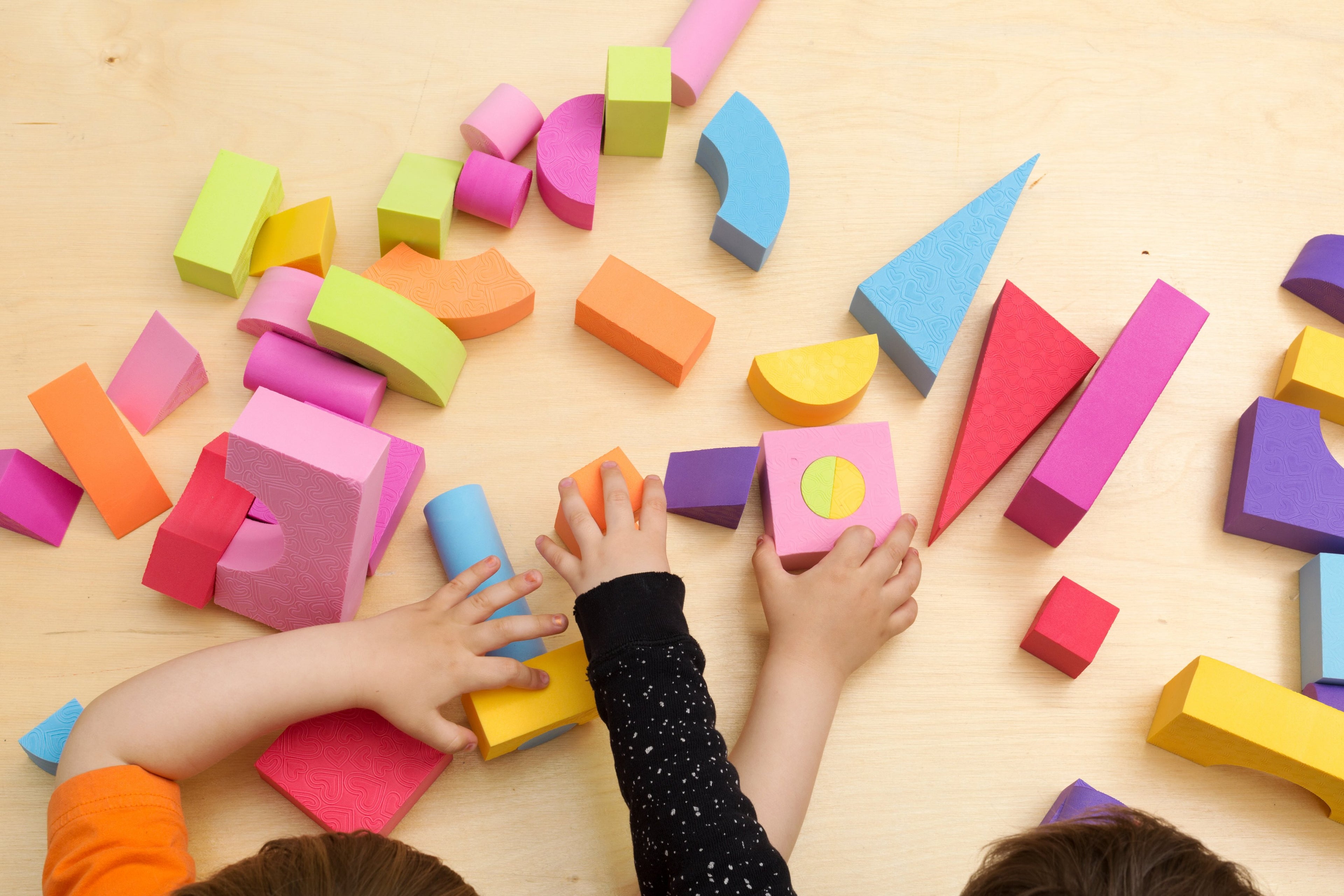 children-sharing-and-playing-with-3d-lego-like bricks of different shapes